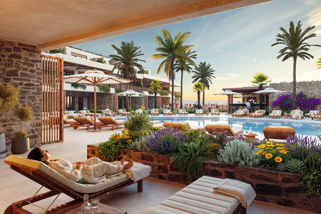 Woman relaxing on a lounge chair by a pool at a resort with palm trees and a bar.