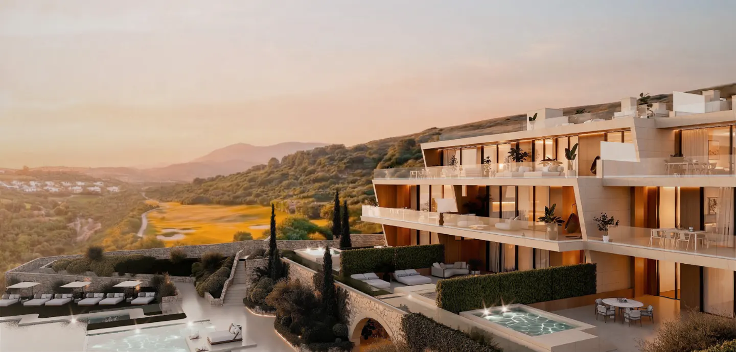 Luxury resort with pools and balconies overlooking a golf course and mountains at sunset.
