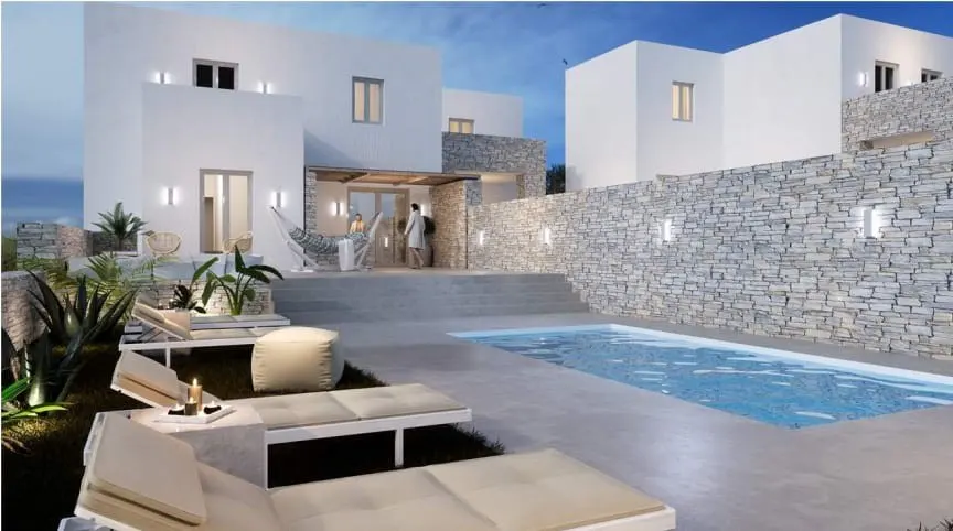 Modern white villa with a pool, stone wall, and lounge chairs. A couple stands on the patio near a hammock.