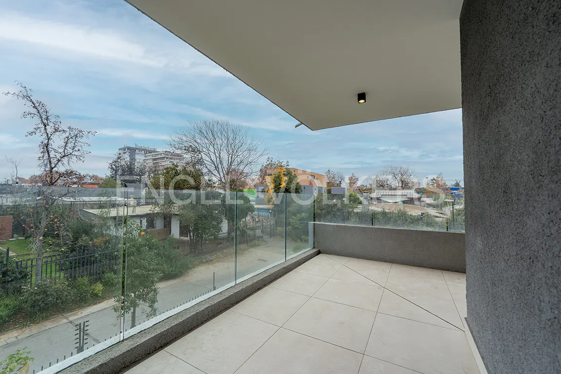 Modern balcony with light-colored tiled floor, glass railing, and a view of a suburban street with trees and buildings.