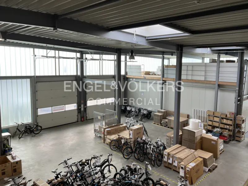 A high angle shot of a large warehouse space with bikes, boxes, and the Engel & Volkers logo.