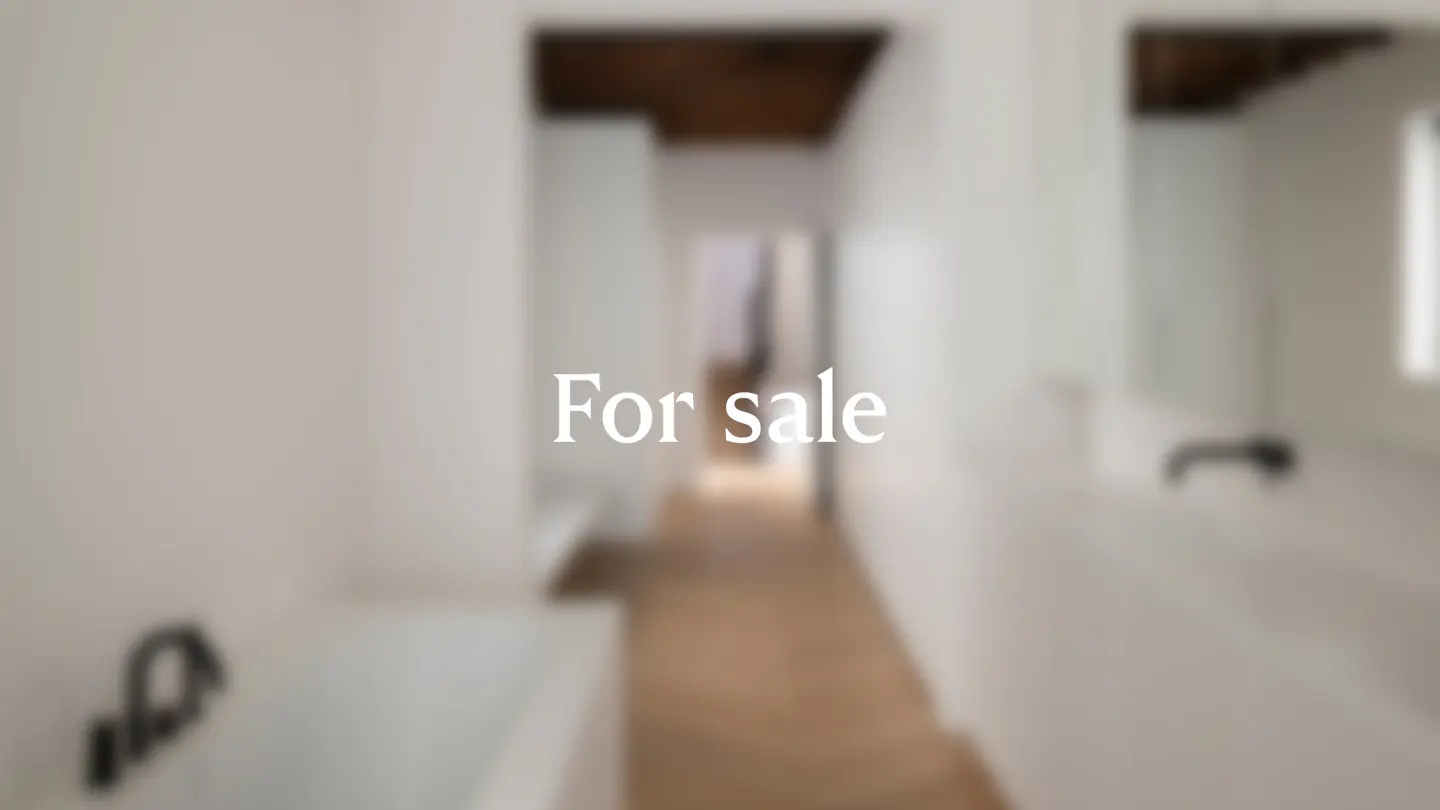 Blurred view of a bright, modern hallway with white walls and light wood floors. "For sale" text overlay.