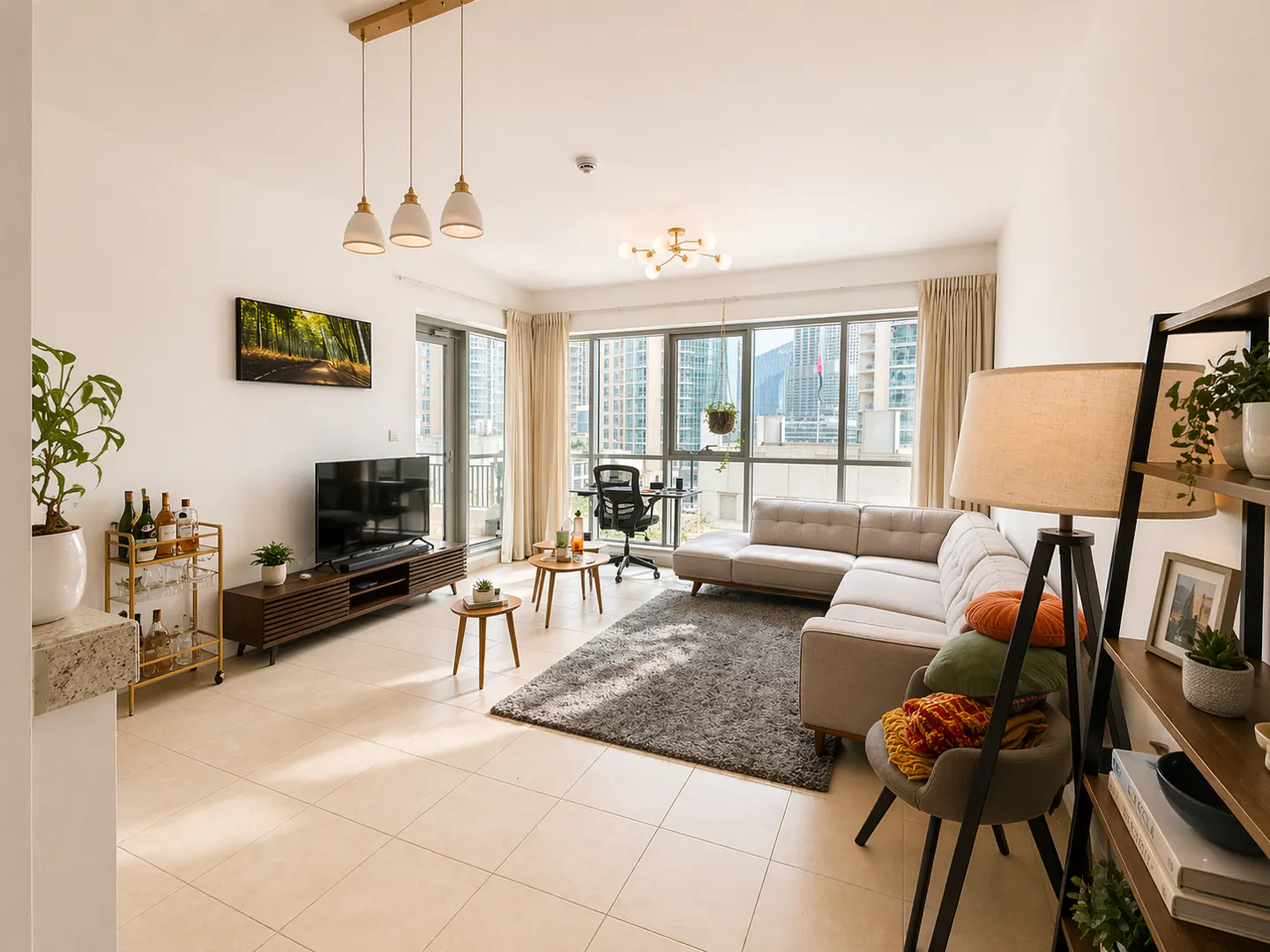 Bright living room with a gray sectional sofa, TV, and large windows showing a city view. A gray rug sits on the tiled floor.