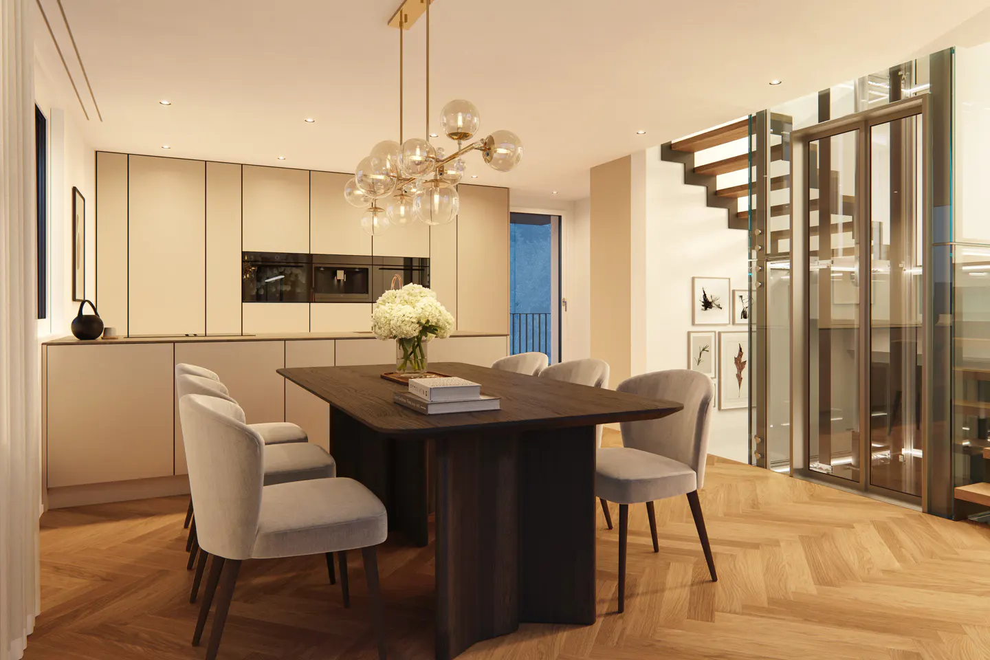 A modern dining area with a dark wood table, light gray chairs, and a glass chandelier. A kitchen and staircase are in the background.