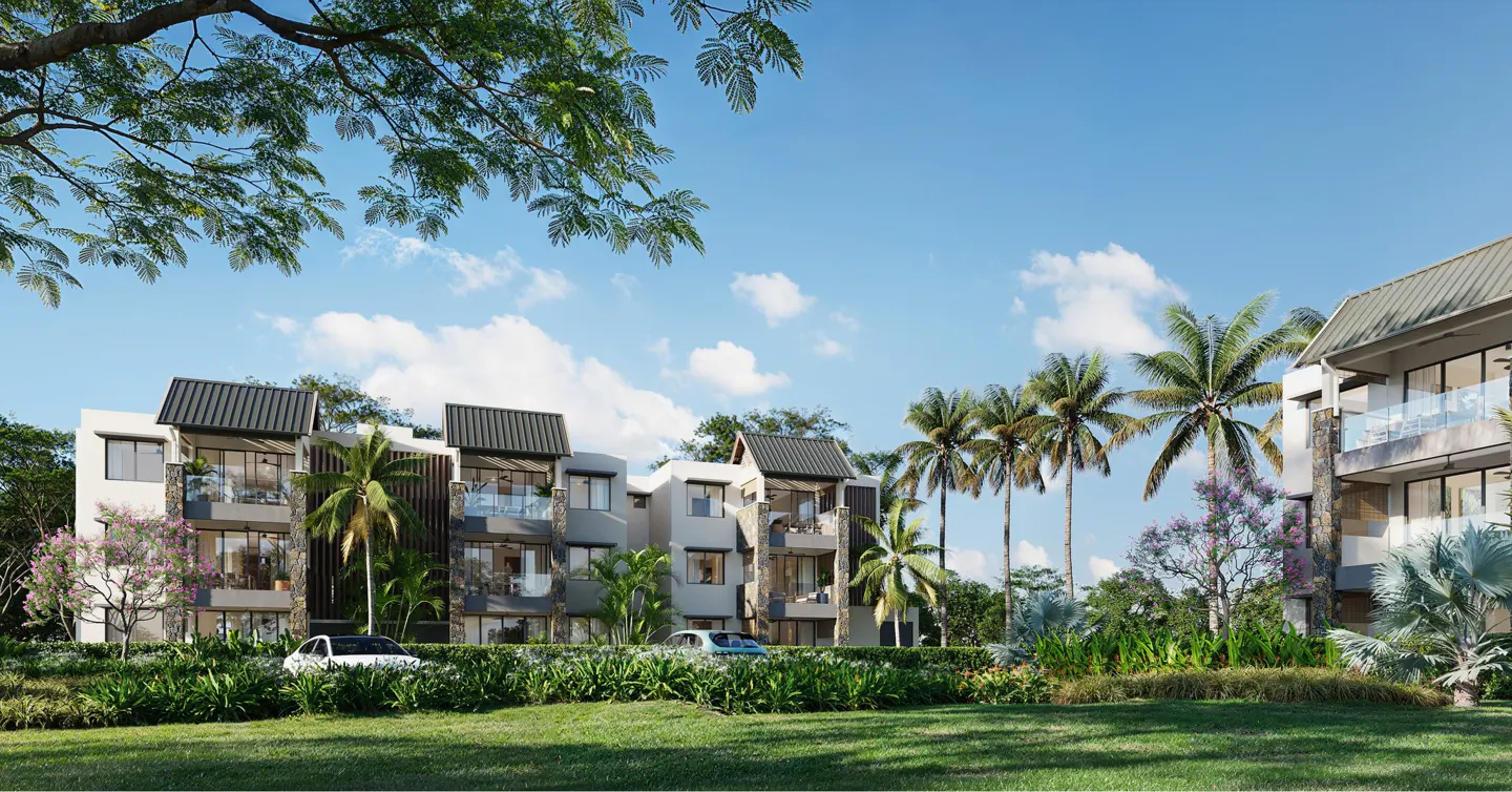 Exterior view of modern, multi-story apartments with palm trees and green lawn under a blue, cloudy sky.