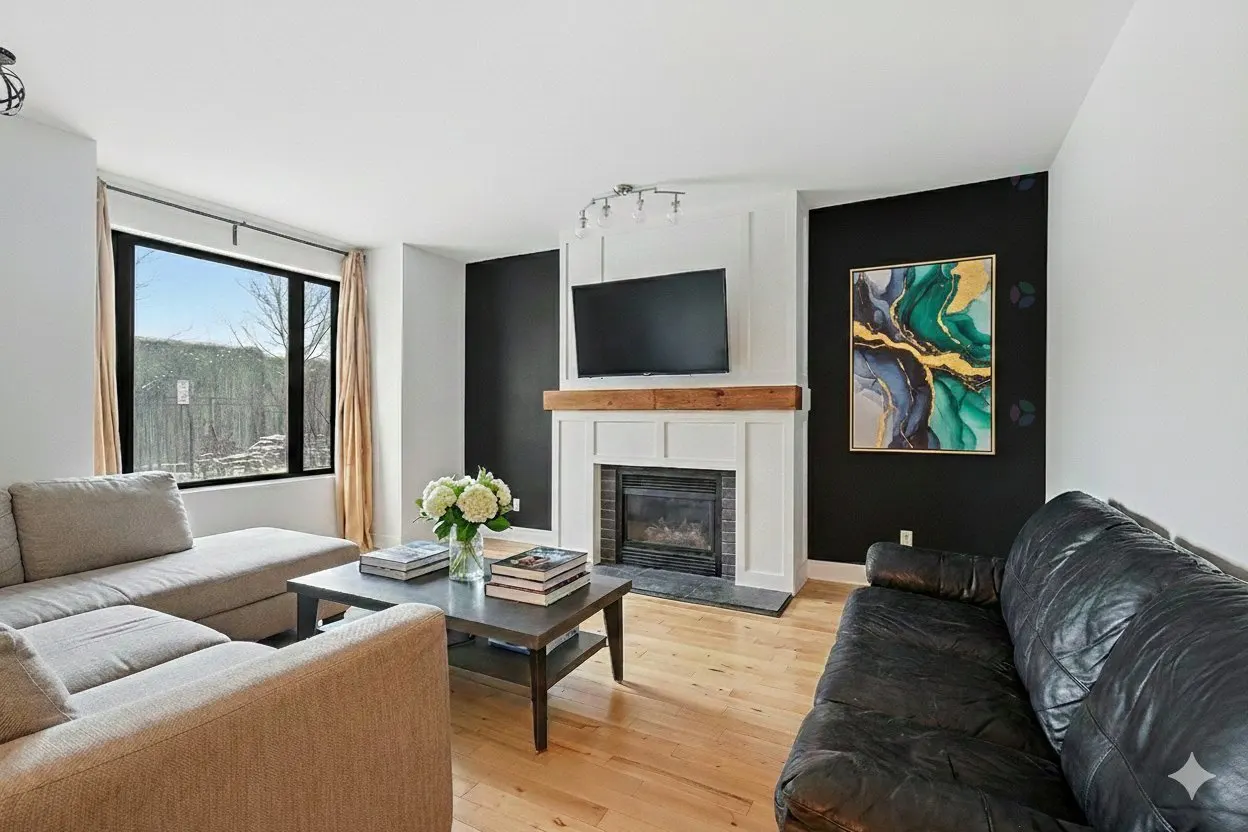 Living room with a beige sectional sofa, black leather sofa, fireplace, TV, and a black accent wall with a colorful painting.