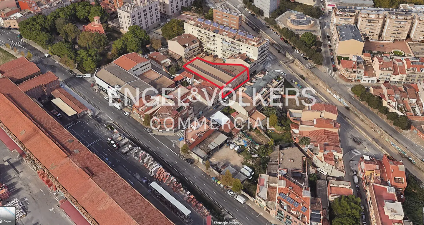 Aerial view of a commercial property outlined in red, surrounded by buildings and greenery in an urban setting.