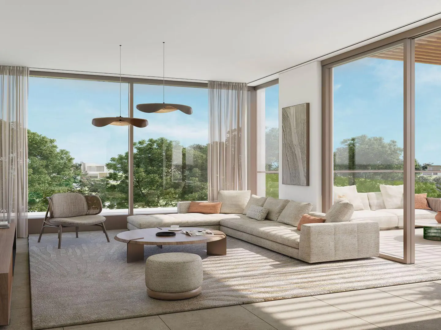 Bright living room with beige sectional sofa, round coffee table, and large windows overlooking green trees. Modern pendant lights hang above.