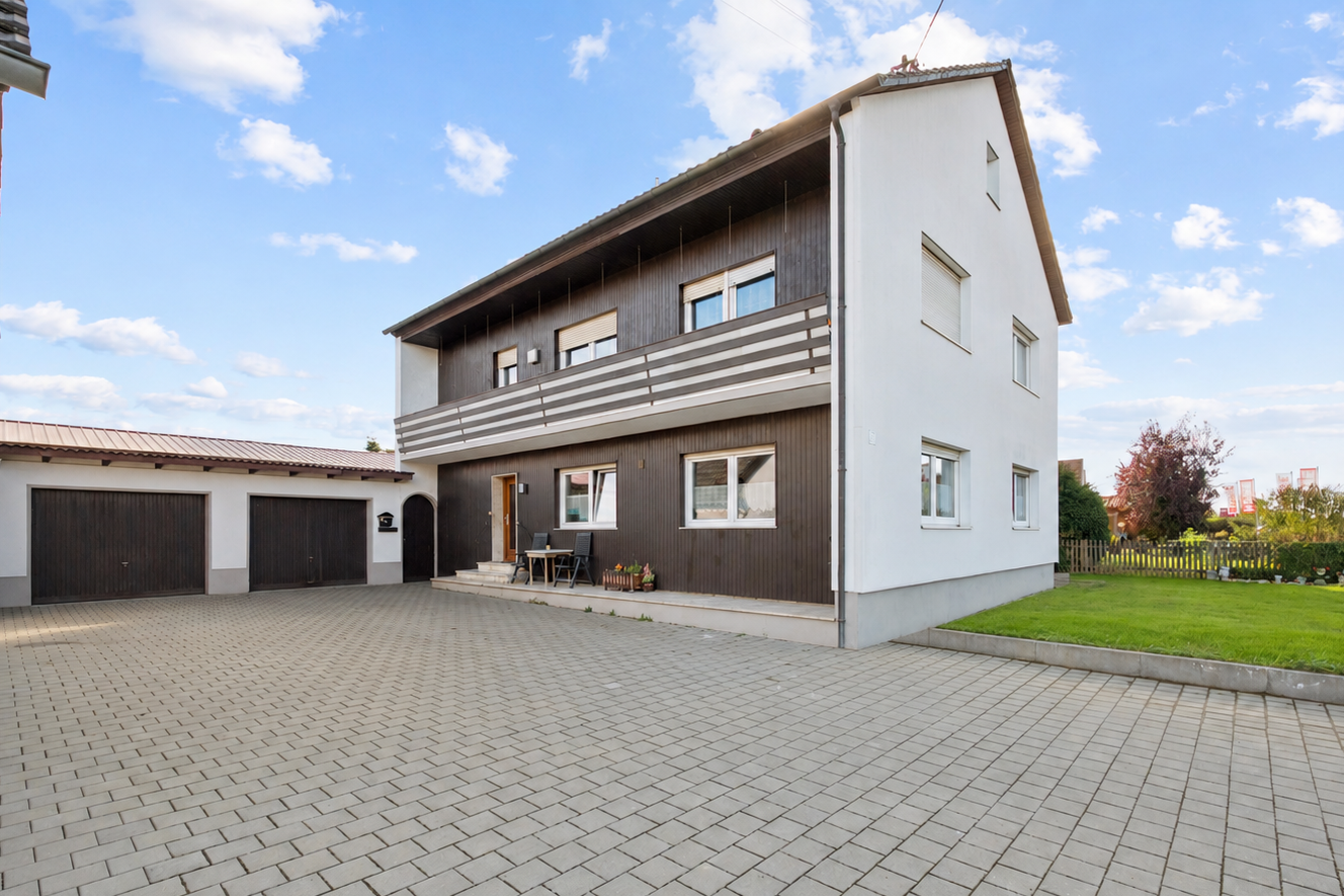 Attraktives Zweifamilienhaus mit zwei Wohneinheiten, Balkon und Garagen