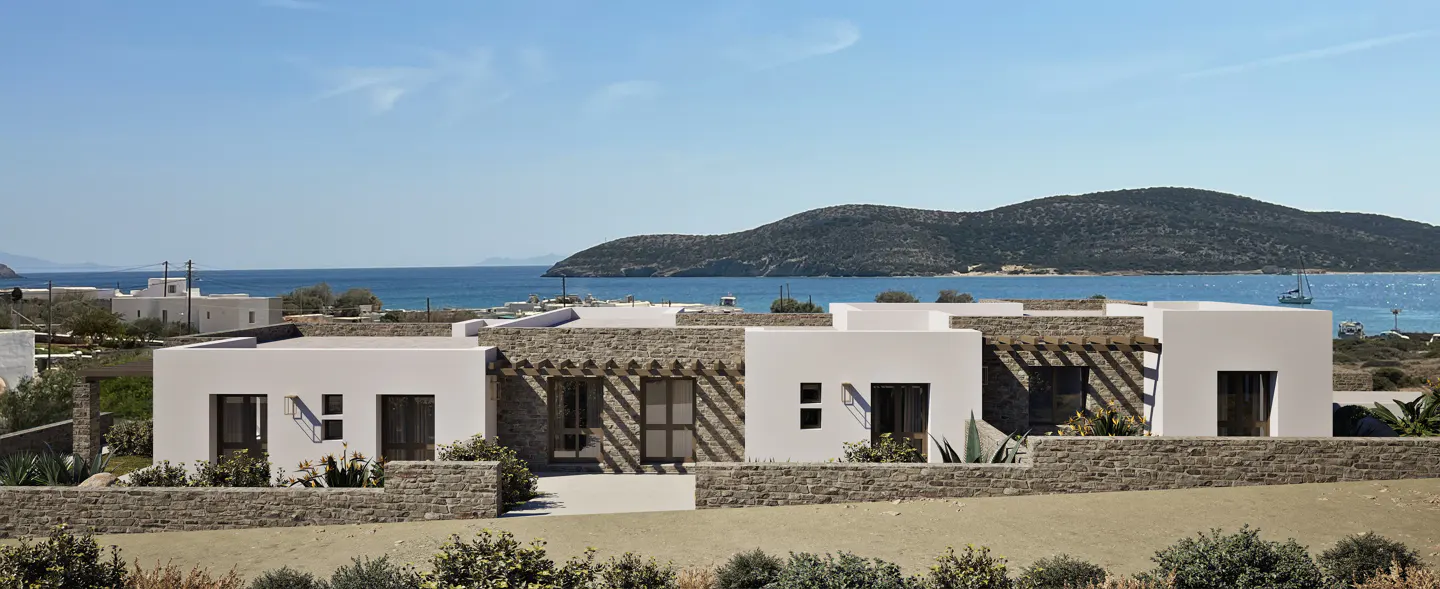 Exterior view of modern white villas with stone accents, overlooking the blue ocean and a distant island under a clear sky.