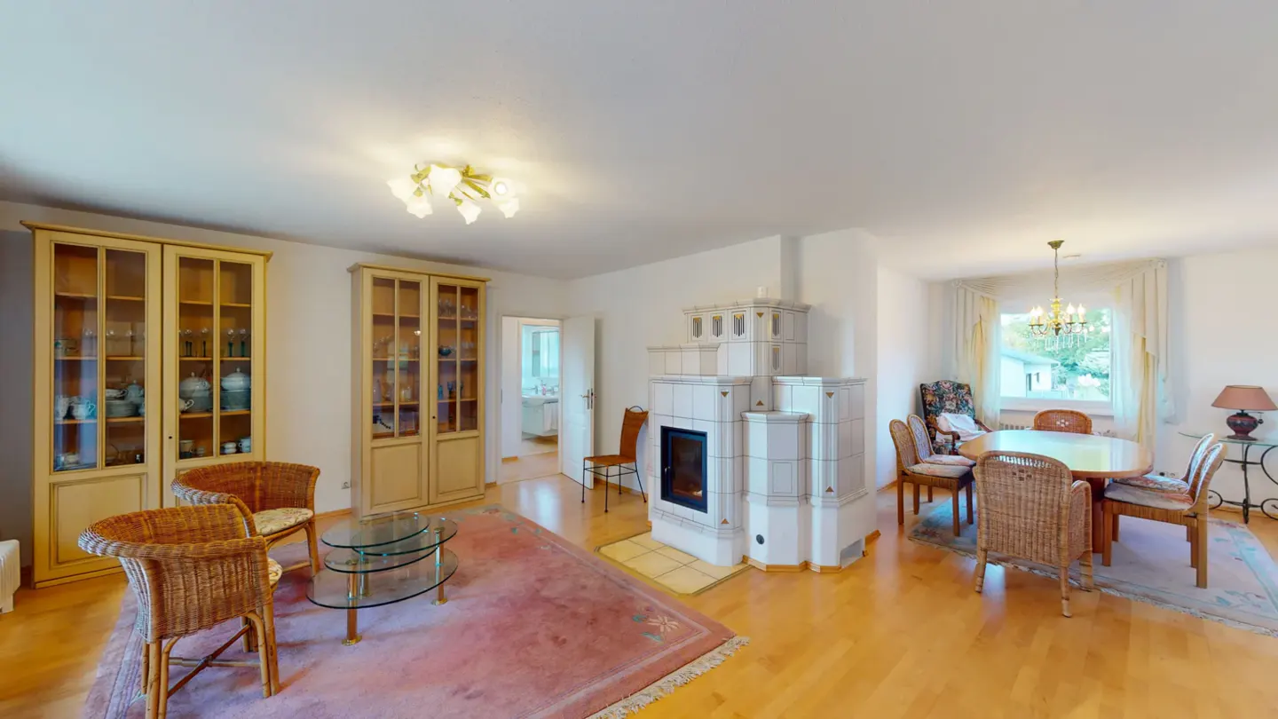 Bright living room with wood floors, cabinets, a white tiled fireplace, and a dining area with a round table.