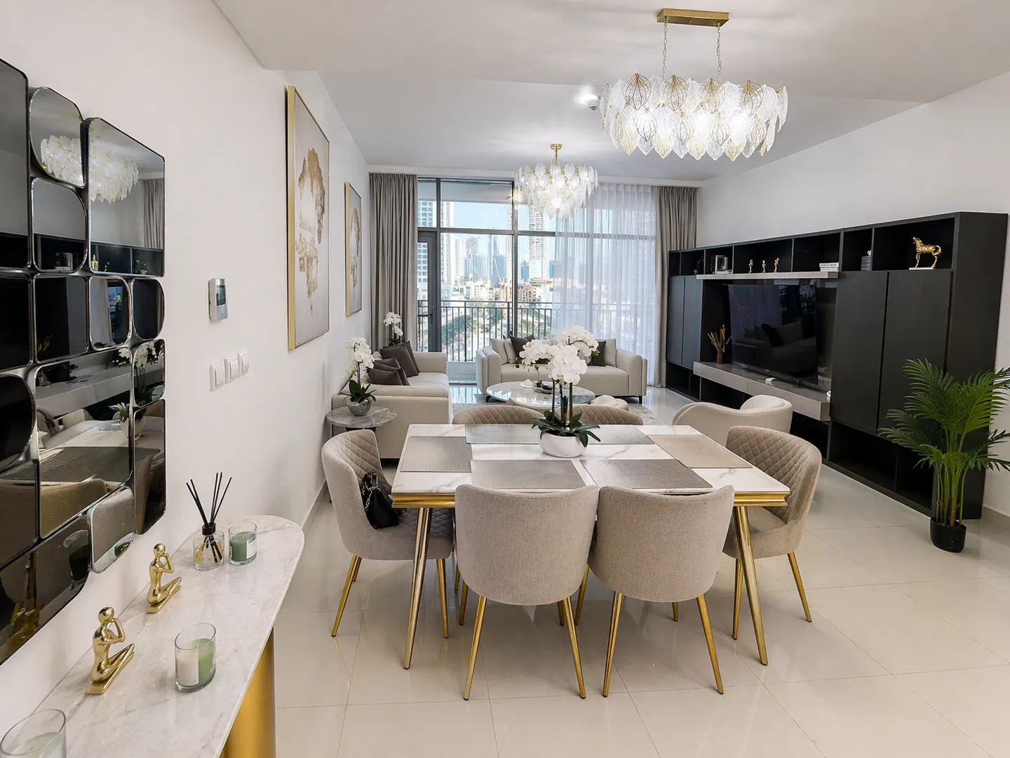 Bright, modern apartment interior with a dining table, living room, and city view. The dining table has beige chairs and a marble top.