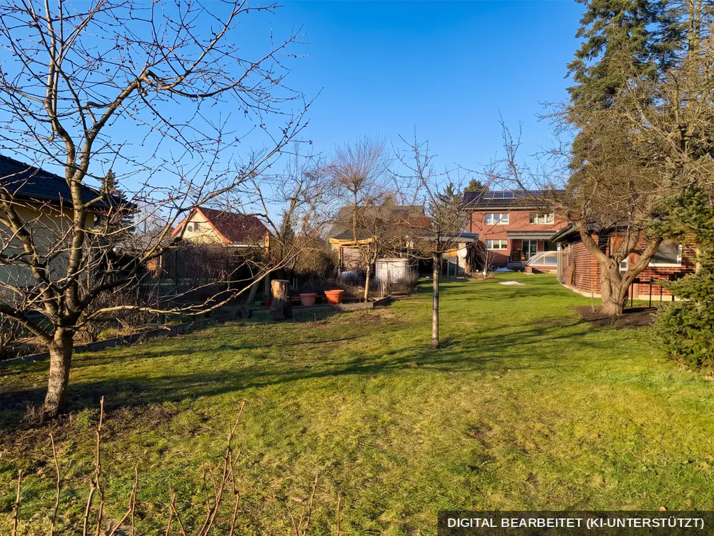 A wide shot of a green backyard with trees, sheds, and houses in the background under a clear blue sky.
