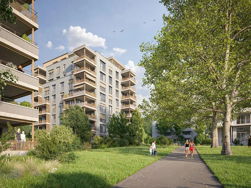 Modern apartment buildings with balconies overlook a green lawn and walking path with people.