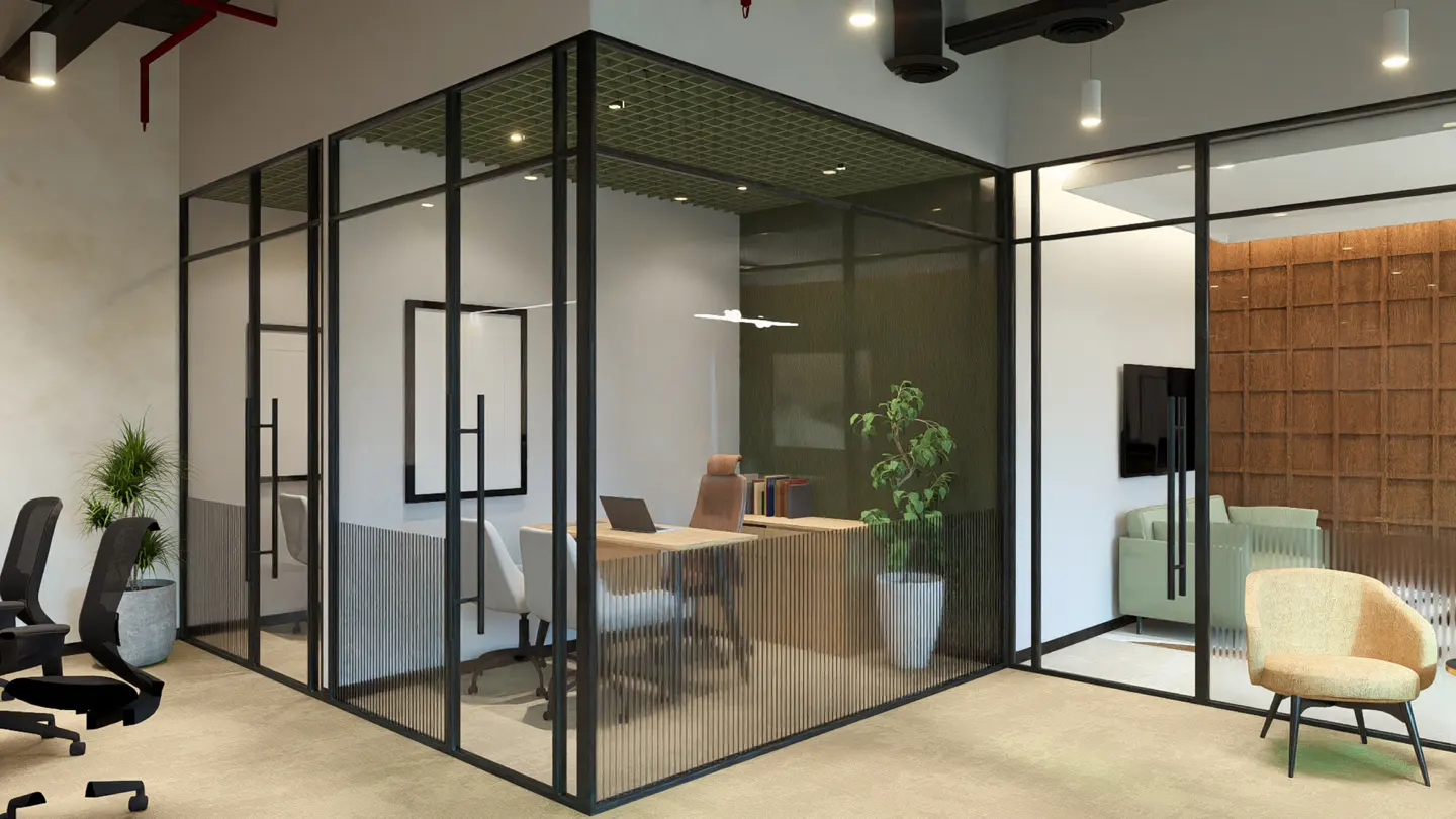 Office interior with glass-walled rooms, featuring desks, chairs, and a lounge area with a green sofa and tan chair.