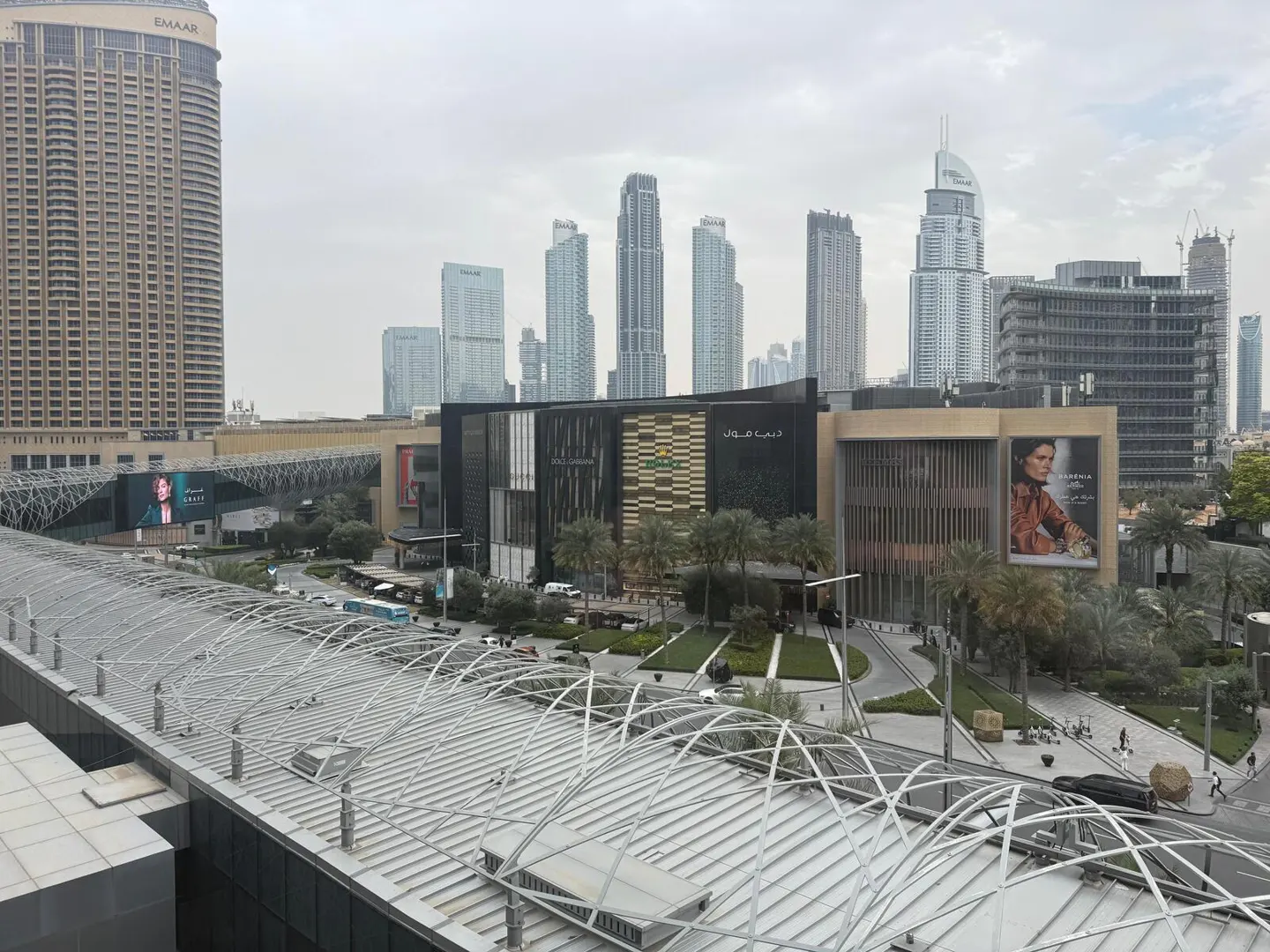 Dubai skyline view featuring the Dubai Mall, skyscrapers, and a covered walkway.