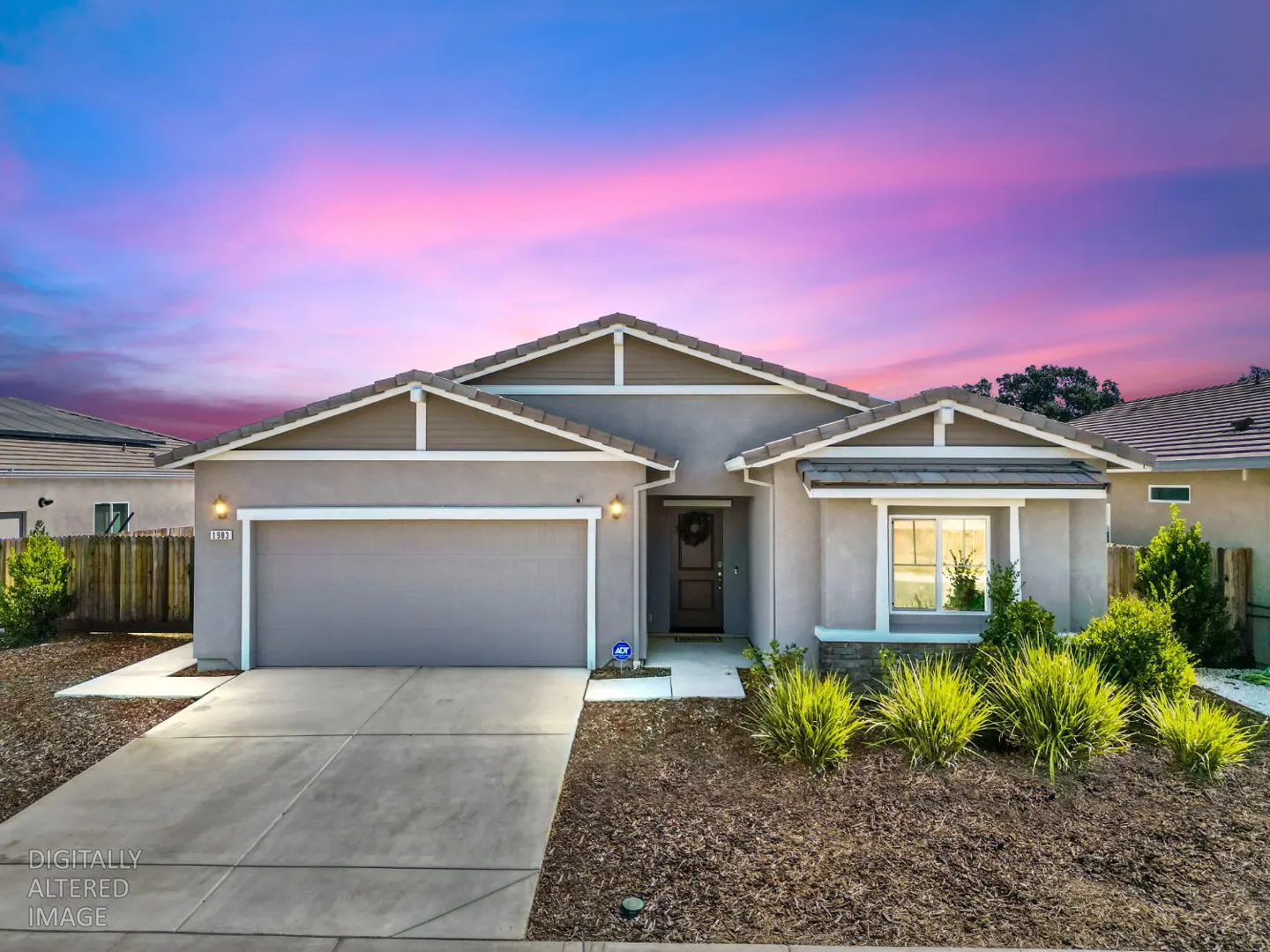 A single-story gray house with a gray roof and a two-car garage under a pink and blue sky.