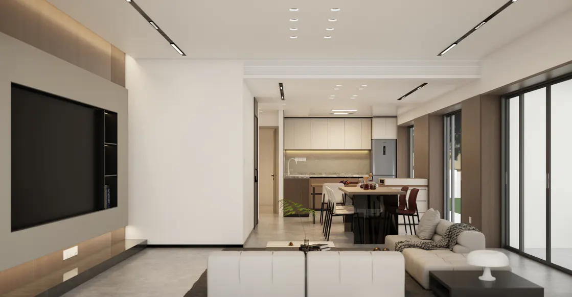 A modern living room with a white sofa, a large TV, and an open kitchen in the background.