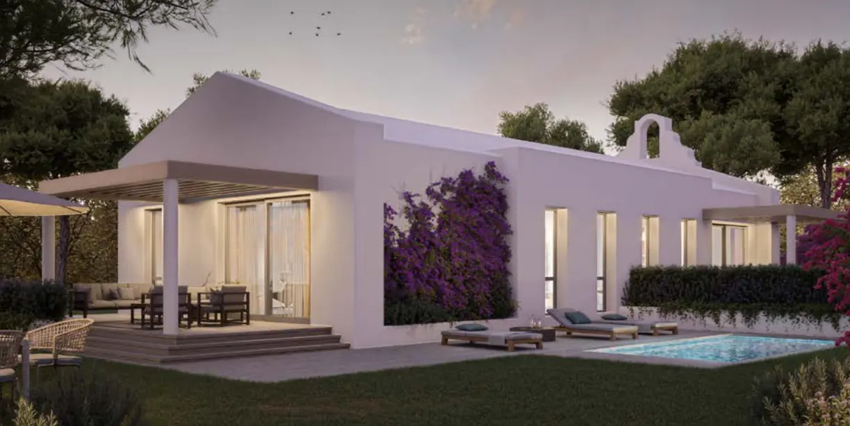 White house with a pool, lounge chairs, and purple flowers on the wall.