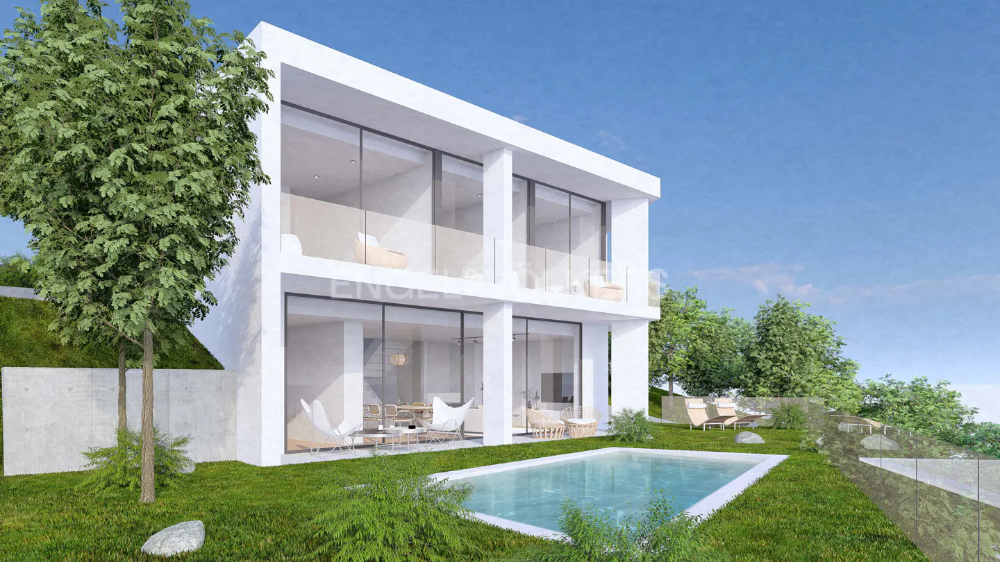 Two-story modern white house with large windows, a pool, and green lawn under a blue sky.