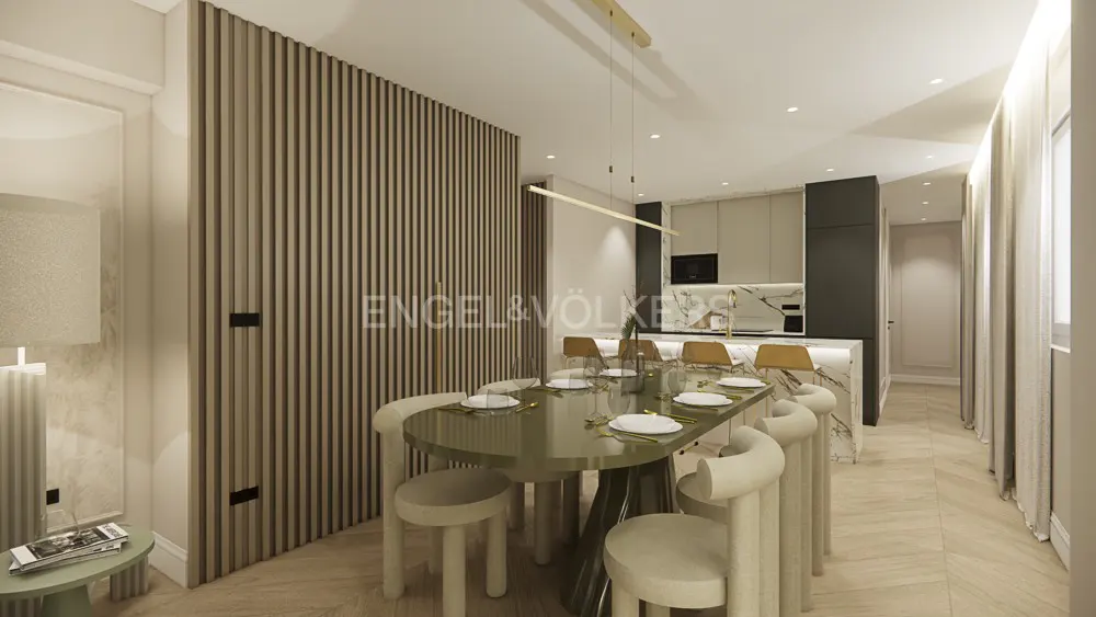 Modern dining area with oval table, cream chairs, and slatted wood wall, leading to a marble-accented kitchen.