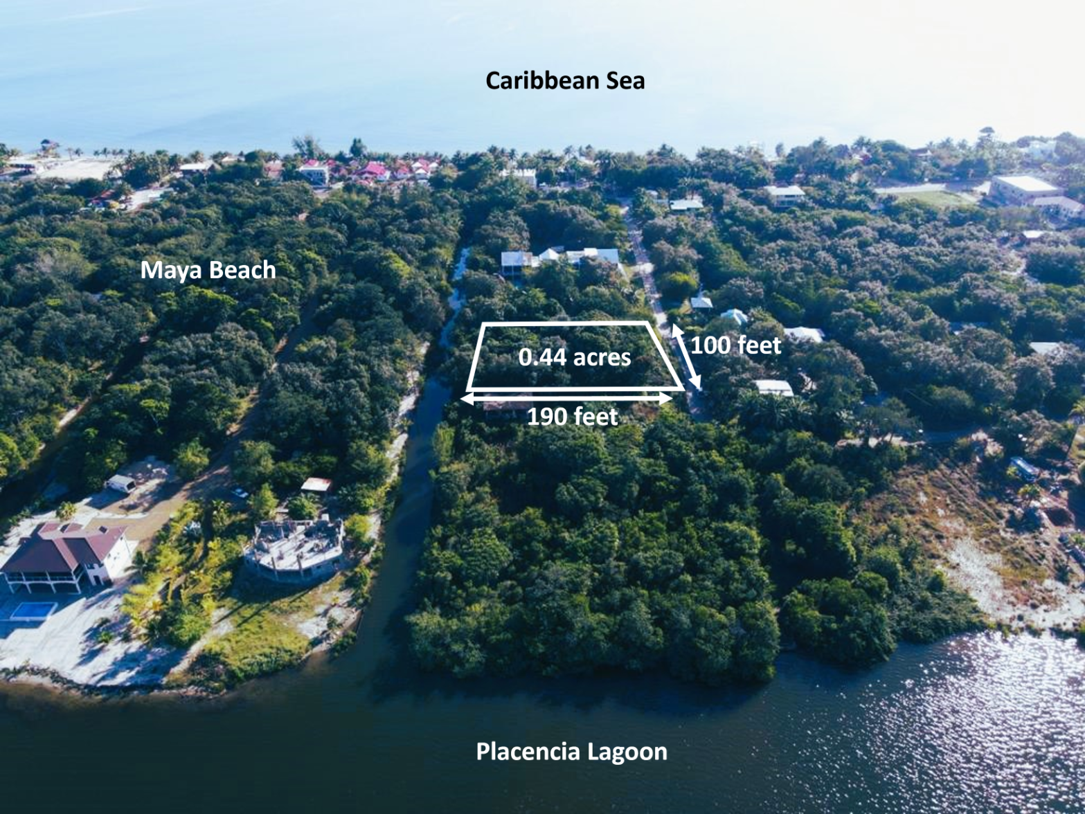 Aerial view of a 0.44-acre wooded lot in Maya Beach, Belize, situated between the Caribbean Sea and Placencia Lagoon.