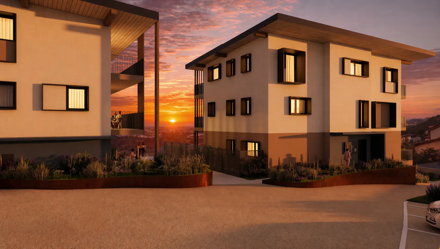 Two modern, multi-story white buildings with dark trim at sunset. People are on a balcony and in the garden.