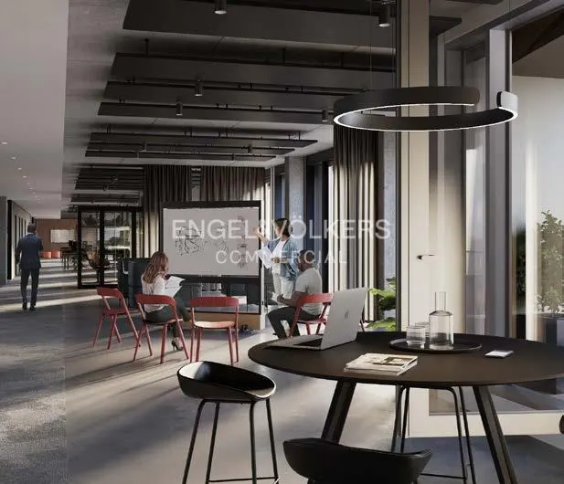 Office space with a round table, black chairs, and a whiteboard presentation by Engel & Völkers Commercial.
