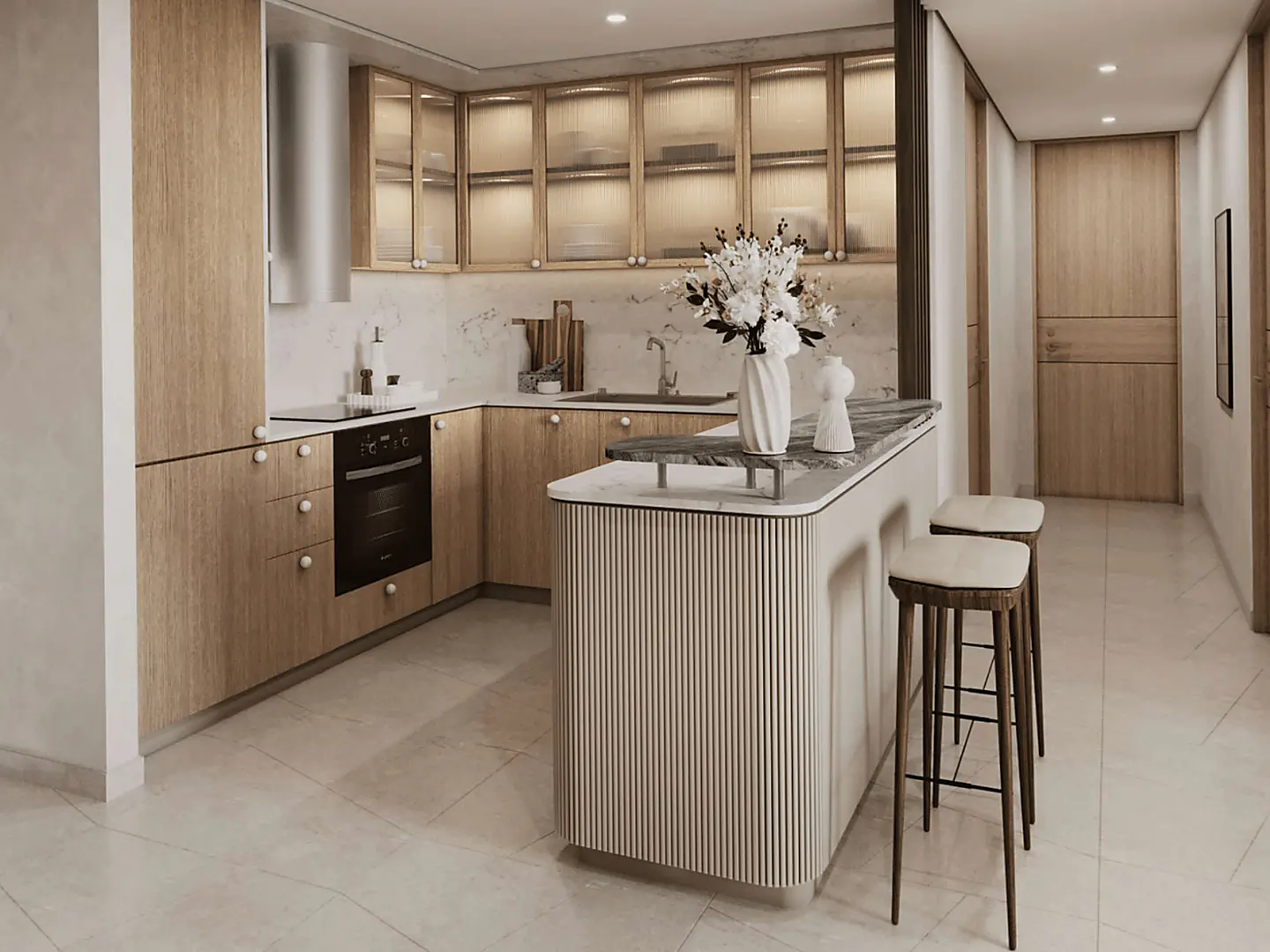 A modern kitchen with light wood cabinets, marble countertops, and a breakfast bar with two stools. A vase of white flowers sits on the counter.