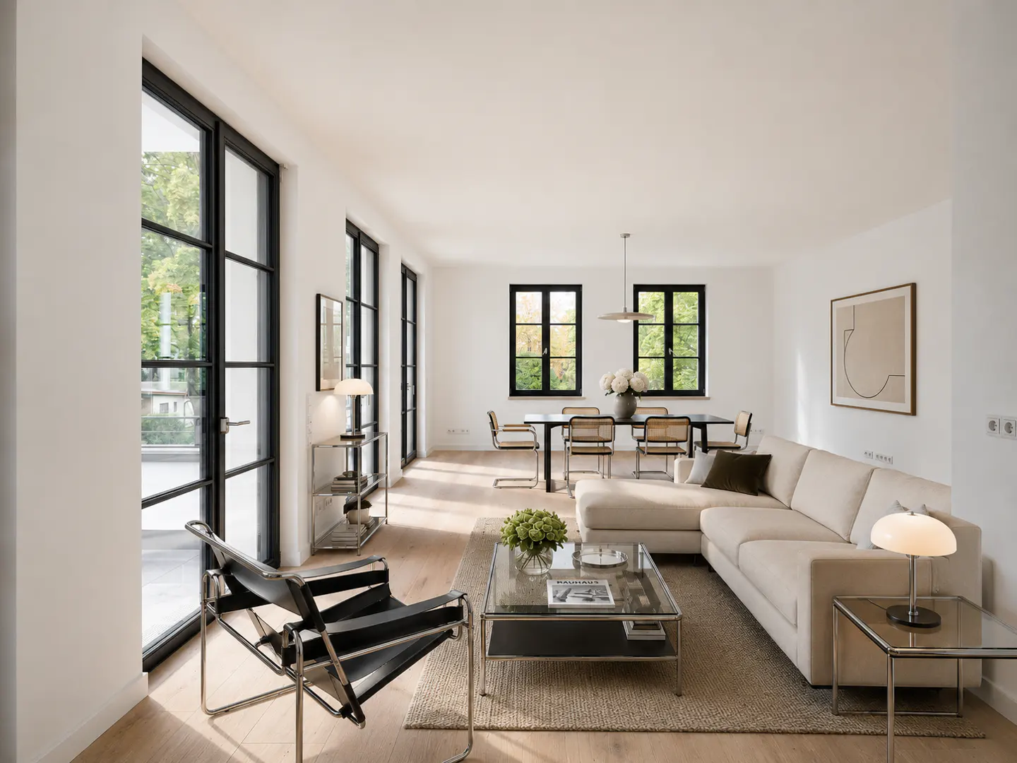 Bright, modern living room with a cream sectional sofa, glass coffee table, black leather chair, and dining area beyond.