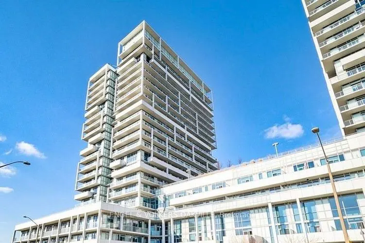 Exterior shot of a modern, white high-rise condo building against a clear blue sky.