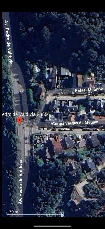 Aerial view of a neighborhood with houses and trees, next to Av. Pedro de Valdivia street, marked with a red pin at address 2055.