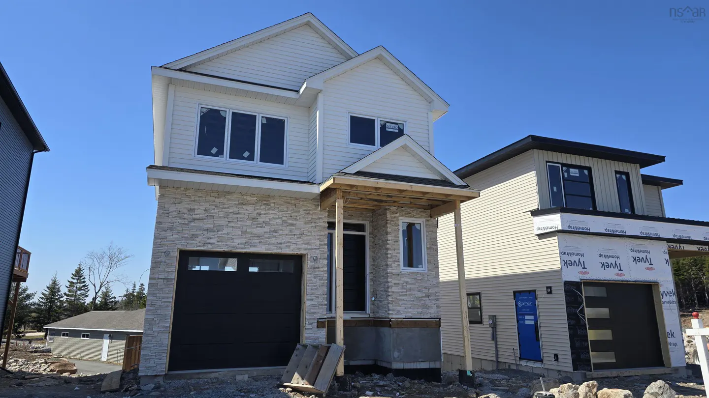 Two-story house with stone and white siding, black garage door, and unfinished porch. Another house is visible to the right.