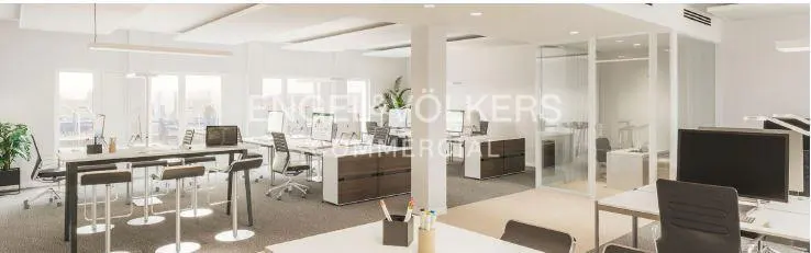 Bright, modern office space with desks, chairs, computers, and a glass-walled conference room. Engel & Völkers logo visible.