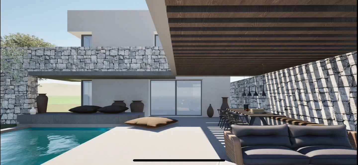 Modern home exterior with a pool, stone walls, and a covered patio with a dining table and sofa.