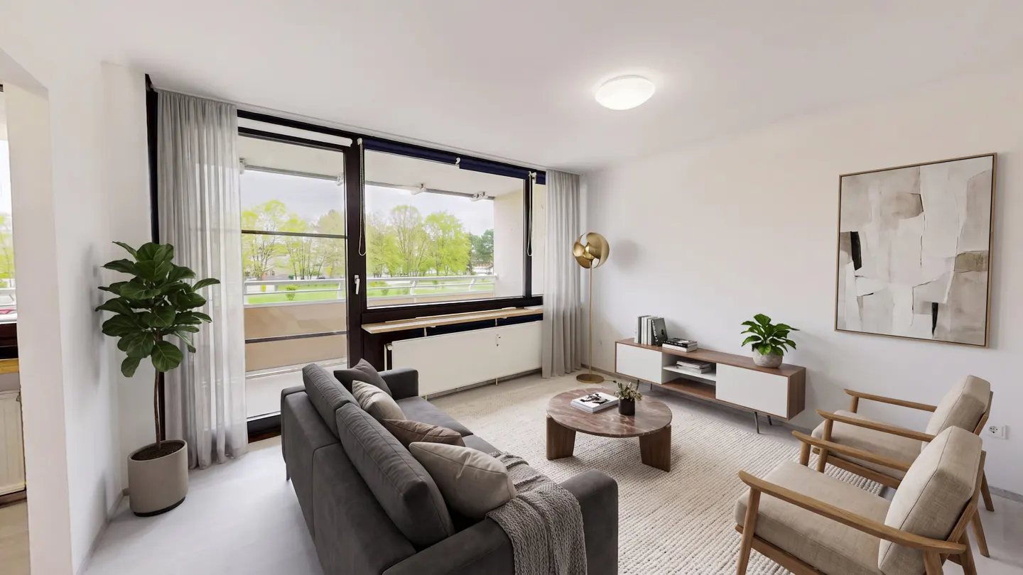 Bright living room with a gray sofa, two chairs, a round coffee table, and a large window overlooking a green landscape.