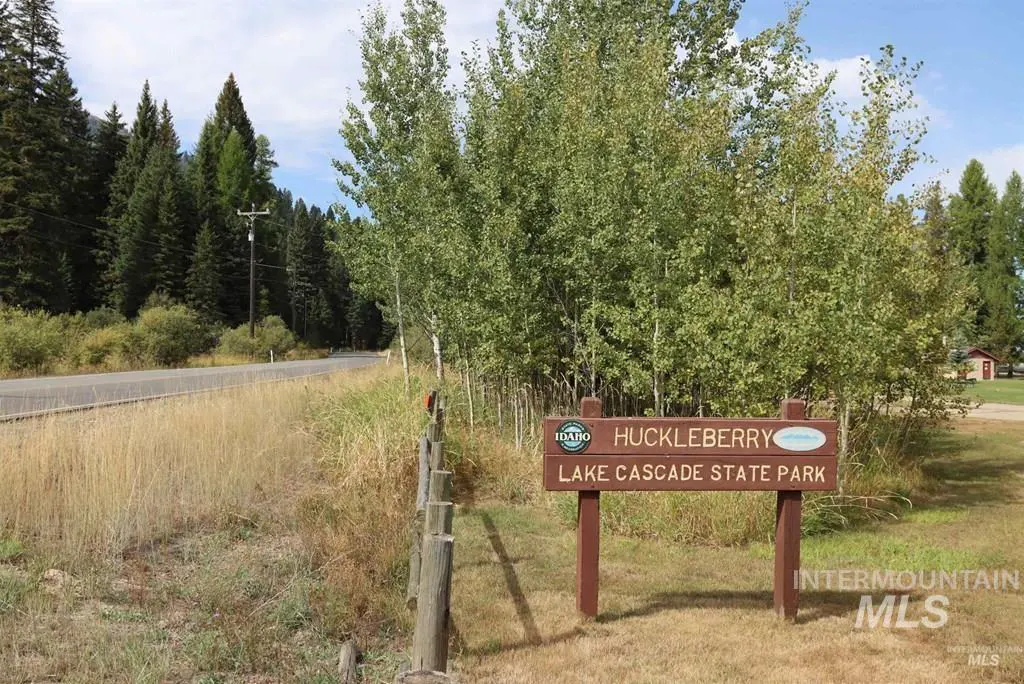 Huckleberry Lake Cascade State Park sign with trees and a road in the background.