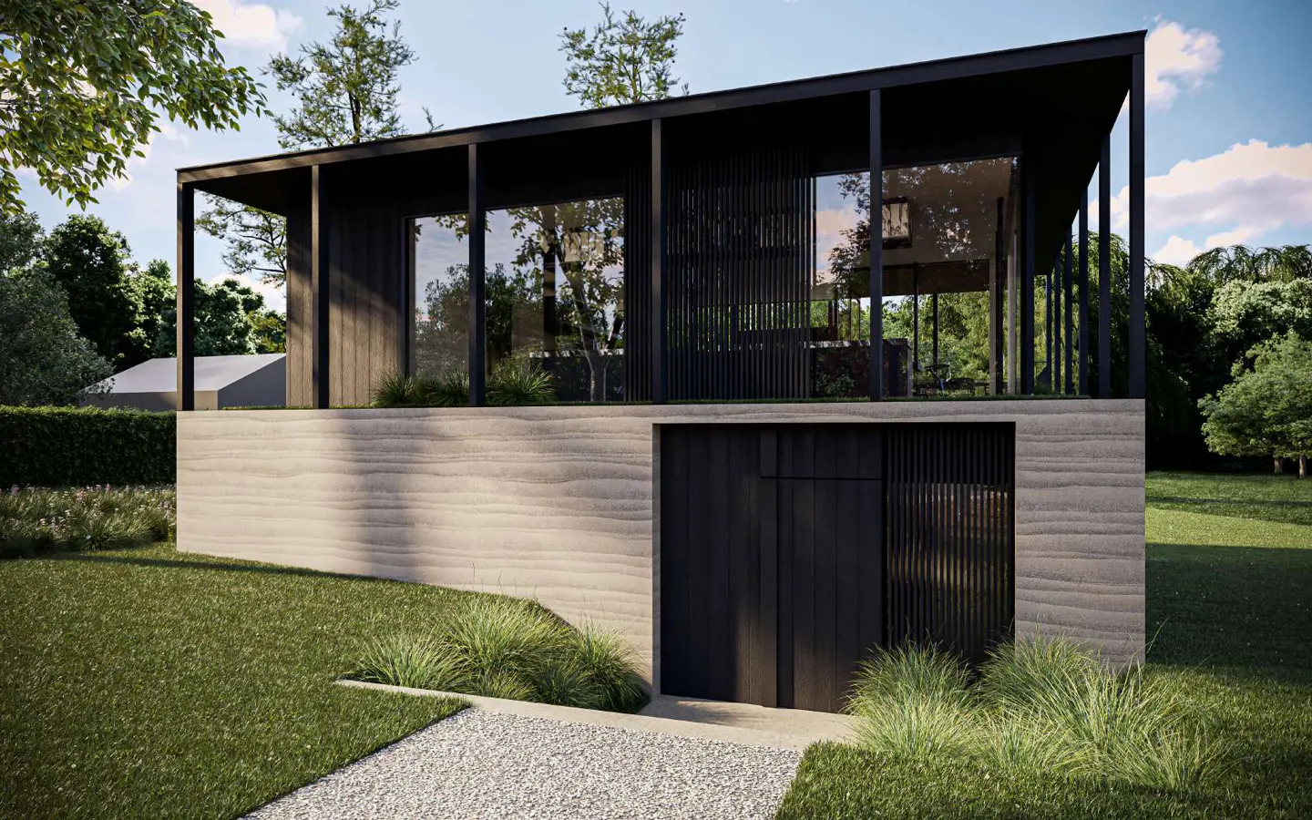 Modern black house with large windows and a concrete base, surrounded by green grass and trees. A gravel path leads to the entrance.