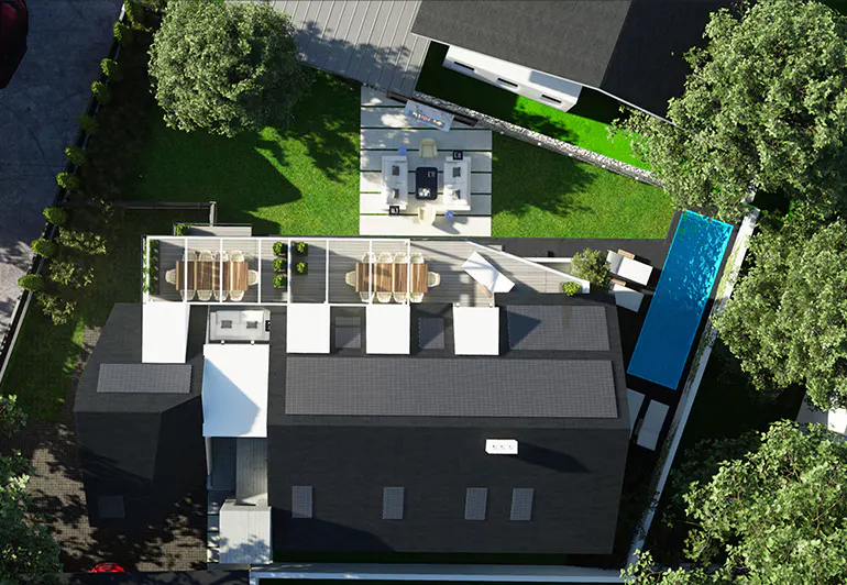 Aerial view of a modern house with a black roof, a pool, a patio, and a green lawn.