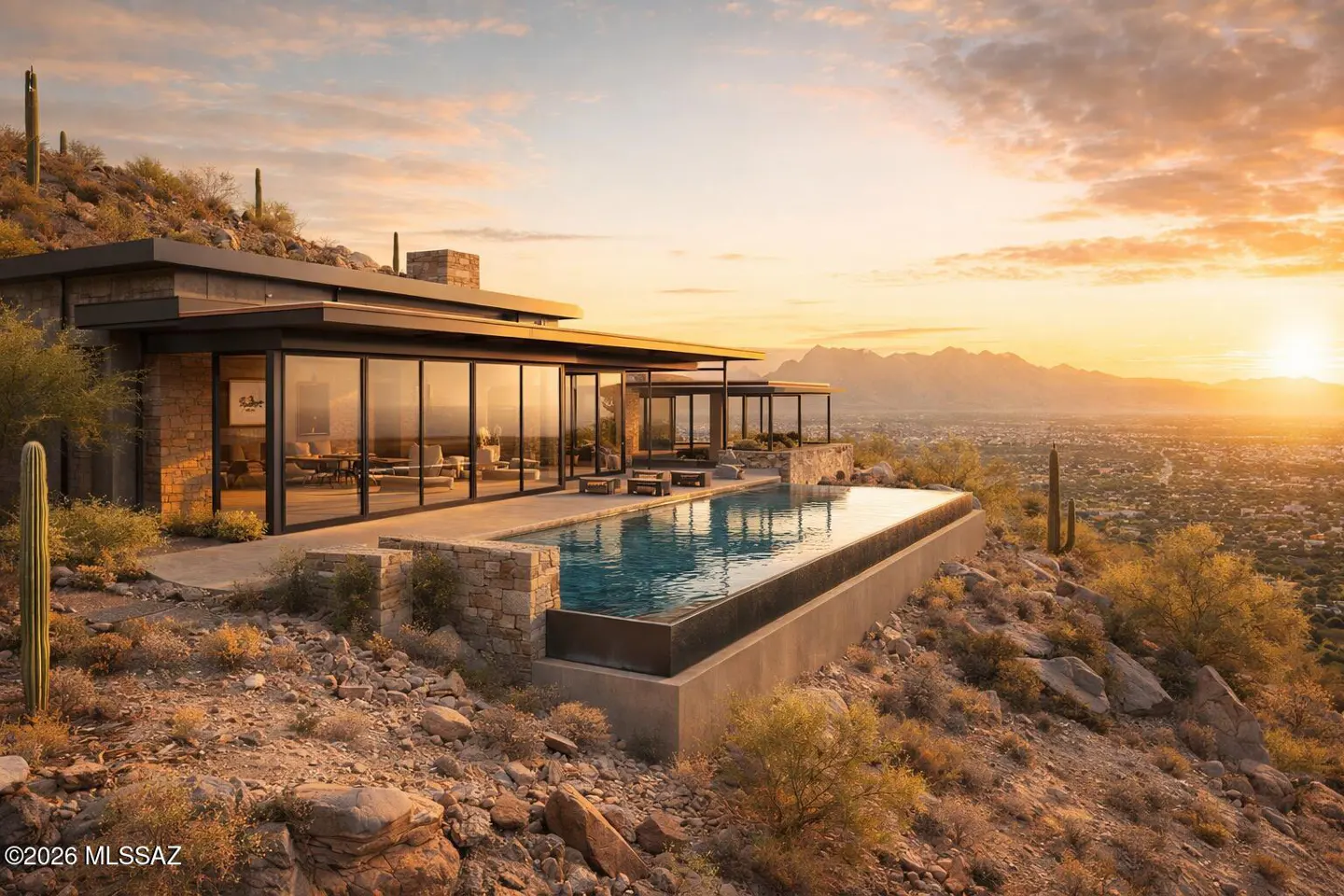 Modern desert home with a pool overlooking a city at sunset. The house has large glass windows and a stone exterior.