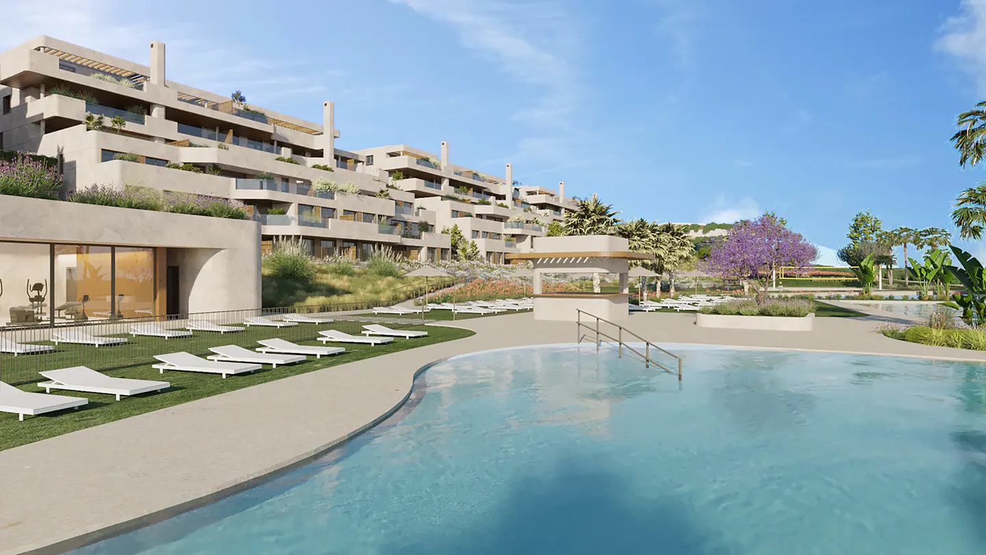 Exterior view of a modern apartment complex with a pool, lounge chairs, and a bar area under a blue sky.