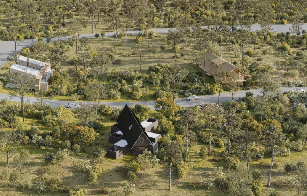 Aerial view of three unique homes nestled in a lush, green forest with a road winding through the landscape.