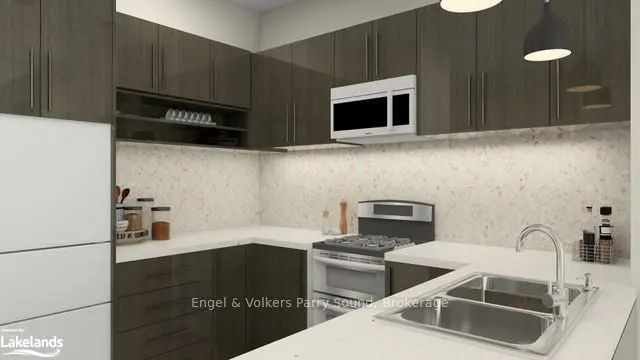 A modern kitchen with dark wood cabinets, white countertops, and stainless steel appliances. A white refrigerator is on the left.