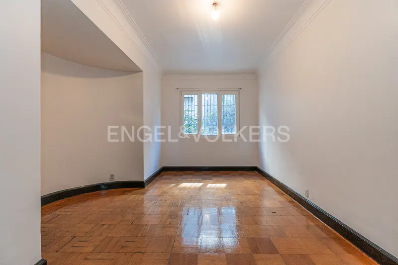 Empty room with parquet floor, white walls, and a window. A light fixture is on the ceiling.