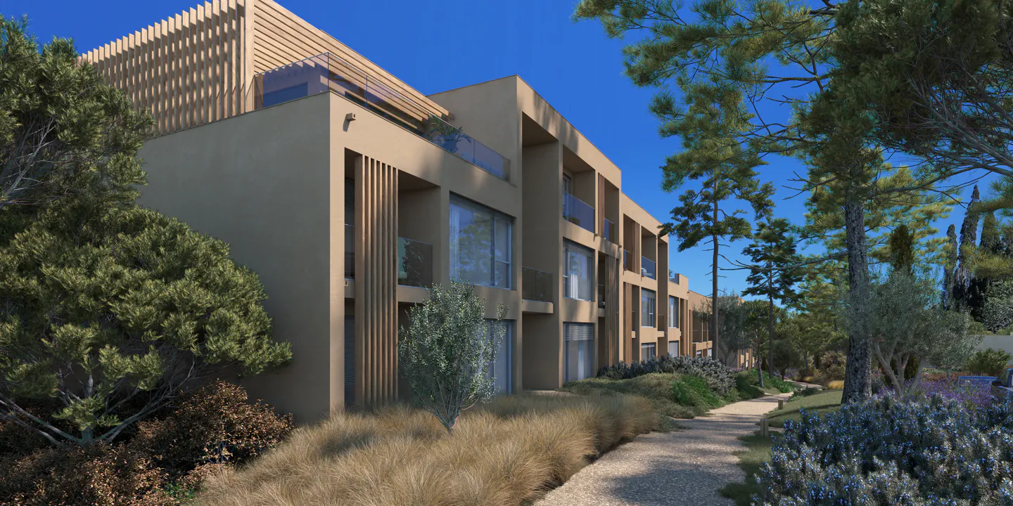 Modern tan apartment building with glass balconies and wood accents, surrounded by lush greenery and a stone pathway under a clear blue sky.