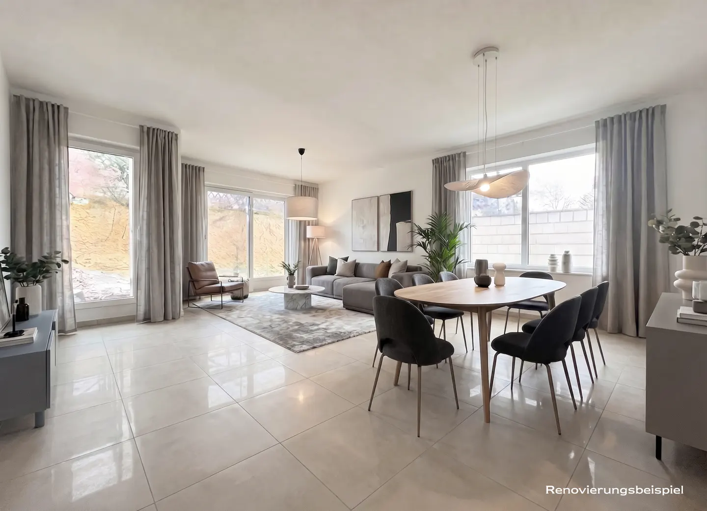 Bright, open-plan living and dining area with large windows, gray sofa, wood table, and black chairs. Neutral color palette.