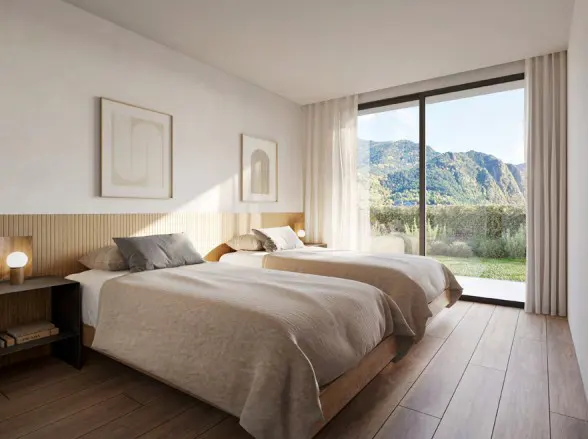 Bright bedroom with two twin beds, wood floors, and a large window with mountain views. Neutral colors and minimalist decor create a serene atmosphere.