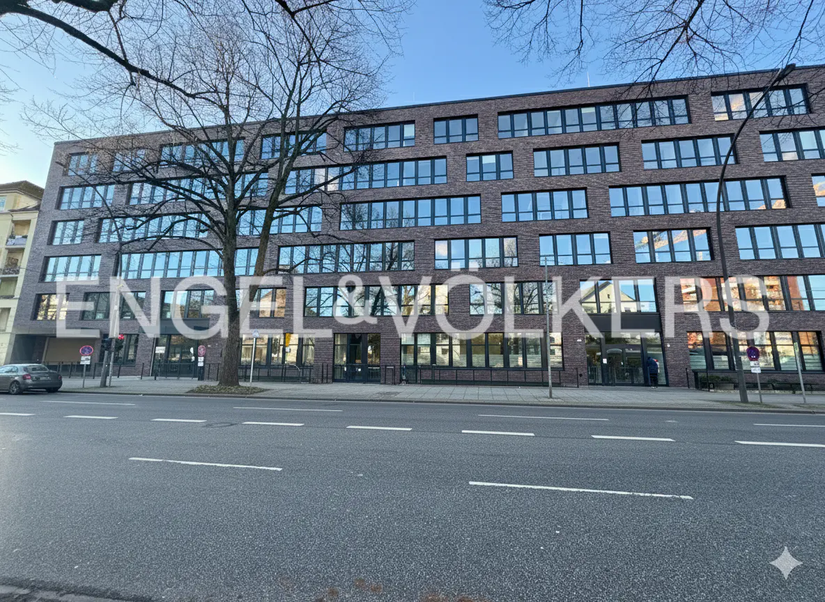 Exterior view of a brick building with many windows, and the Engel & Volkers logo superimposed on the facade.