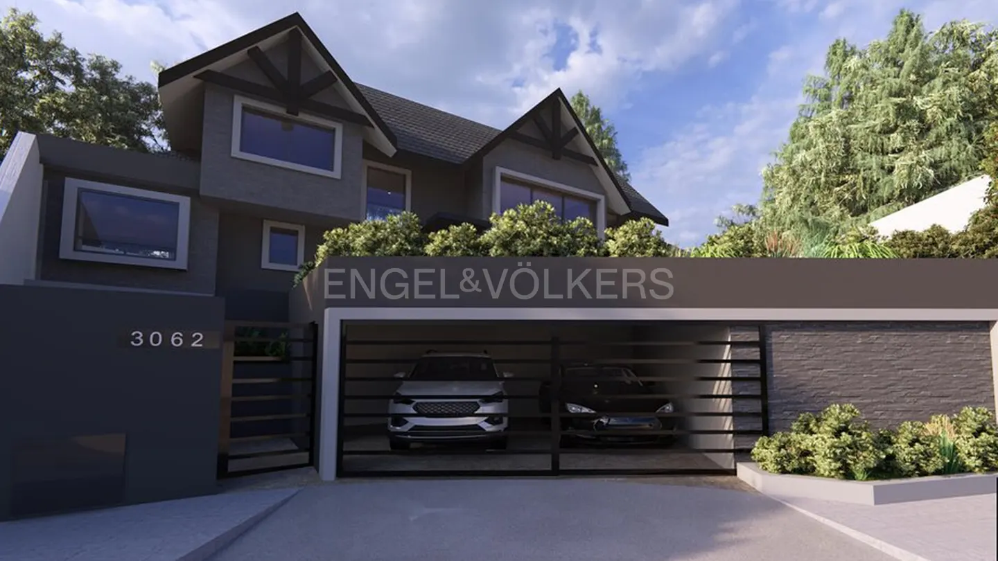 Exterior view of a gray two-story house with a black roof and an Engel & Völkers sign above the garage. Two cars are parked inside.