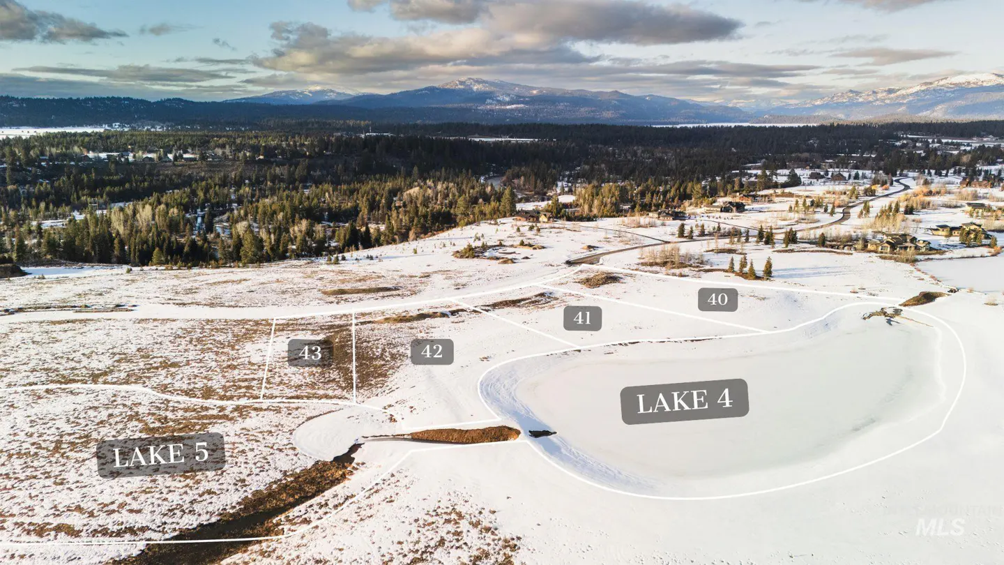 Aerial view of snowy land plots, labeled 40-43, Lake 4, and Lake 5, with trees, mountains, and a lake in the background.